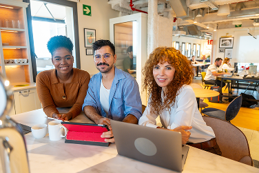 Drie beslissers bekijken samen een B2B website tijdens een overleg aan tafel